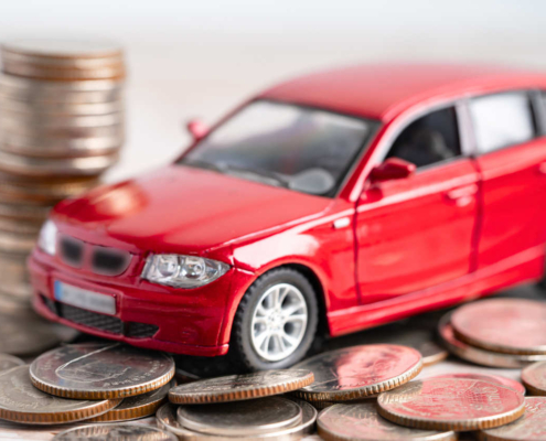 Czerwone auto diesel stoi na monetach, co symbolizuje nowy holenderski podatek od samochodów spalinowych od 2027 roku.